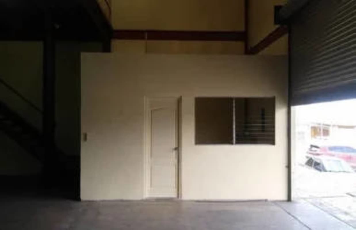 View inside warehouse with shutter door, mezzanine level for office space in Llano Bonito Panama