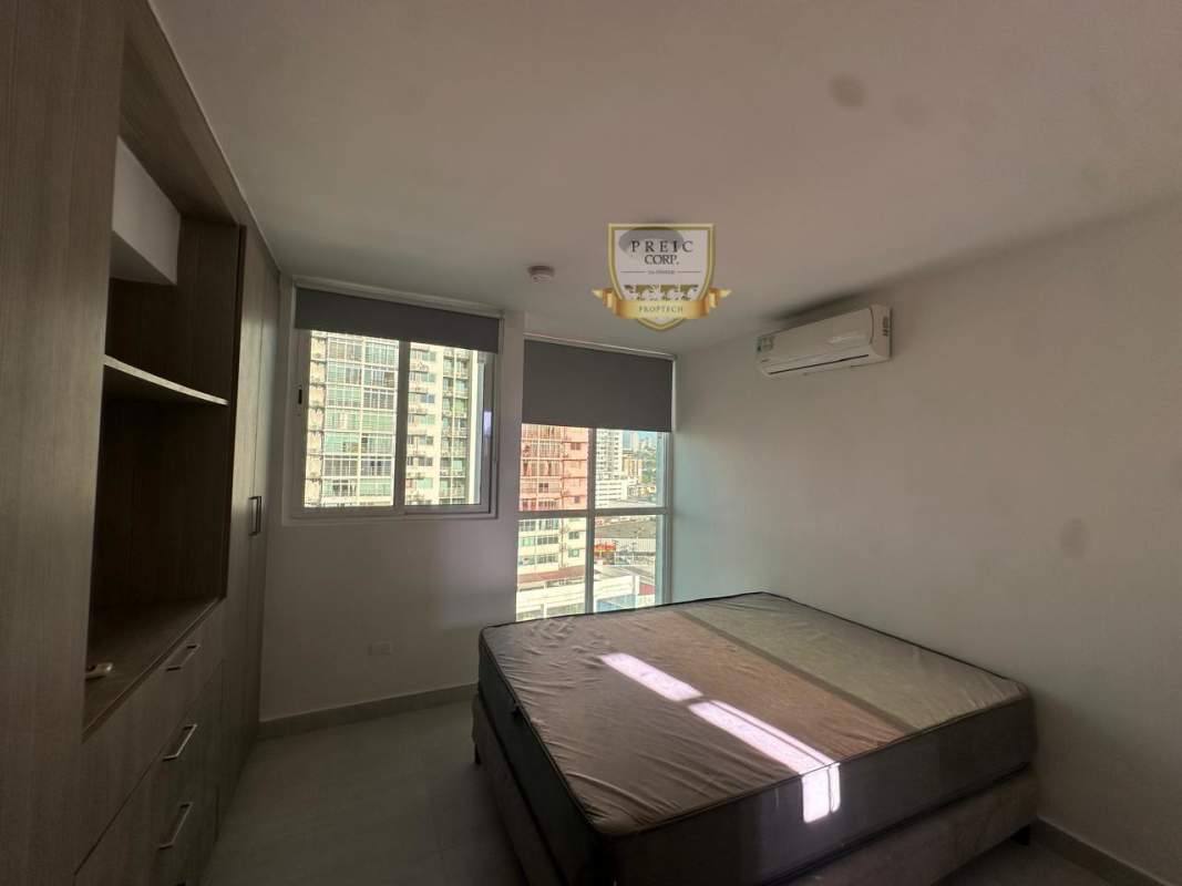Bedroom with large windows and city skyline view in PH Metropolitan Park Panama
