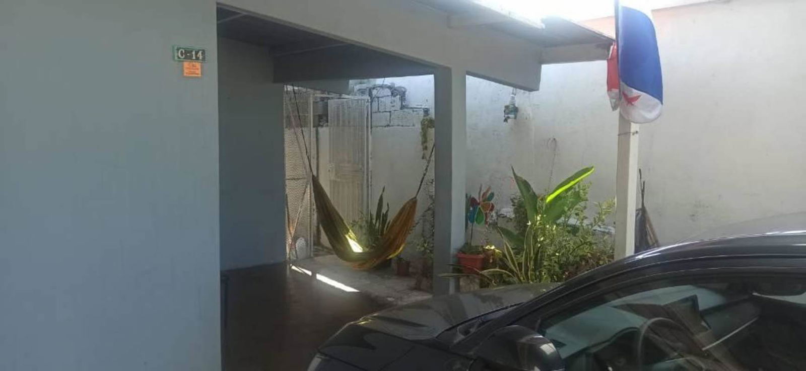 Carport covered with parked cars, hammock hanging and garden patio area Villa Lucre Panama