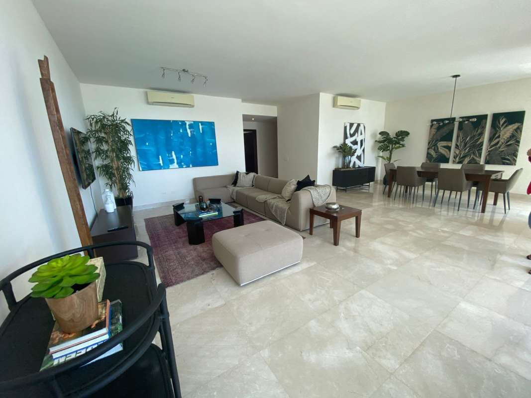 Furnished living room with marble floors, floor-to-ceiling windows, and ocean view balcony in PH Marabierto Panama