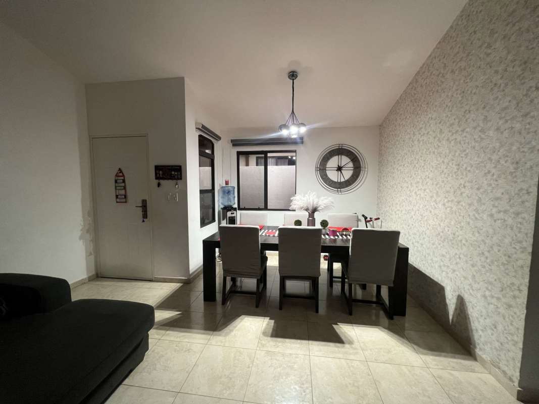 Spacious living room with sectional sofa, large window and tiled floor in house PH Vistas del Lago Tocumen