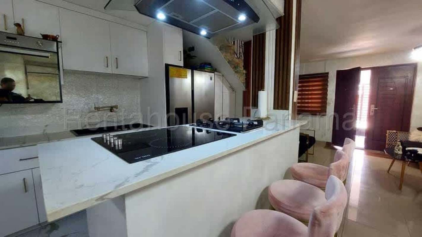 Open modern kitchen with bar pink stools marble counters Condado del Rey home rental