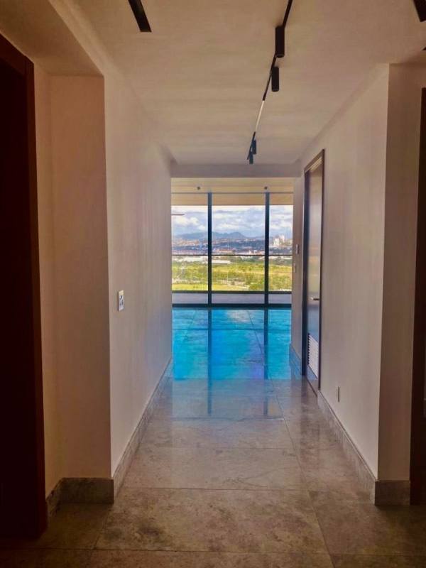 Bright hallway with marble flooring and panoramic windows at Empire Residences Santa Maria Panama City