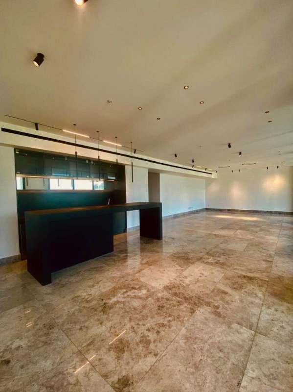 Luxury open-plan living with kitchen island, marble floors, and windows at Empire Residences Santa Maria Panama