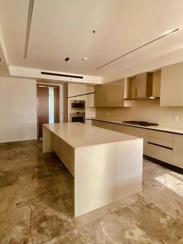 Minimalist kitchen island with beige marble, built-in oven and stylish cabinets in Empire Residences Panama
