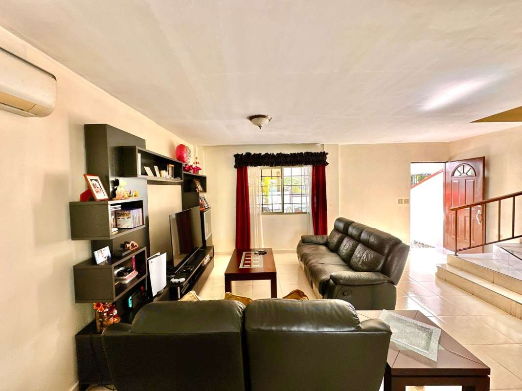 Contemporary living room with black sofas, entertainment unit, AC in Panama house