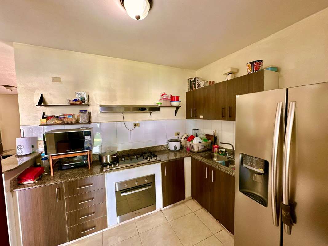 Kitchen with granite countertops, gas stove, stainless refrigerator in Las Cumbres Panama house