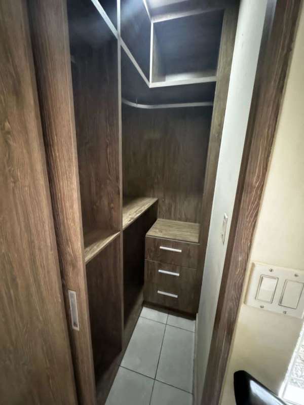Custom walk-in closet with wooden cabinets and sliding door Villas Castel Novo Juan Díaz Panama