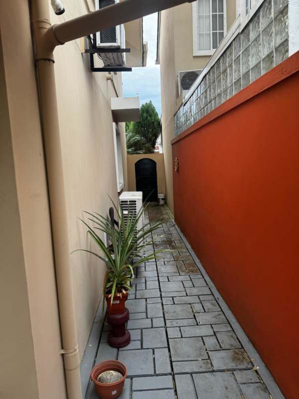 Side garden walkway with AC units and plants Villas Castel Novo Juan Díaz Panama