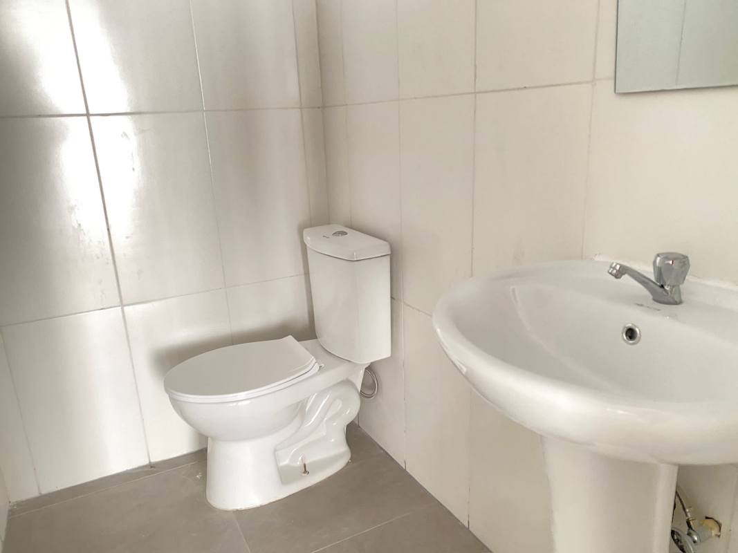 Two bathrooms within commercial unit for rent on Via España with tiled walls and pedestal sinks
