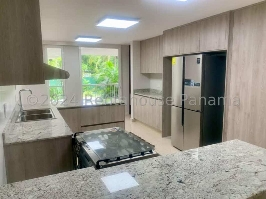 Bright living room with floor-to-ceiling windows overlooking gardens in luxury home Altos del Golf Panama