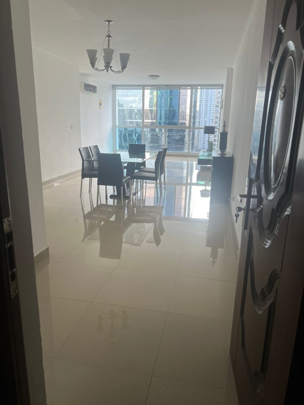 Exterior of PH The Palm showing glass facade and urban street with parked cars in Obarrio Panama City