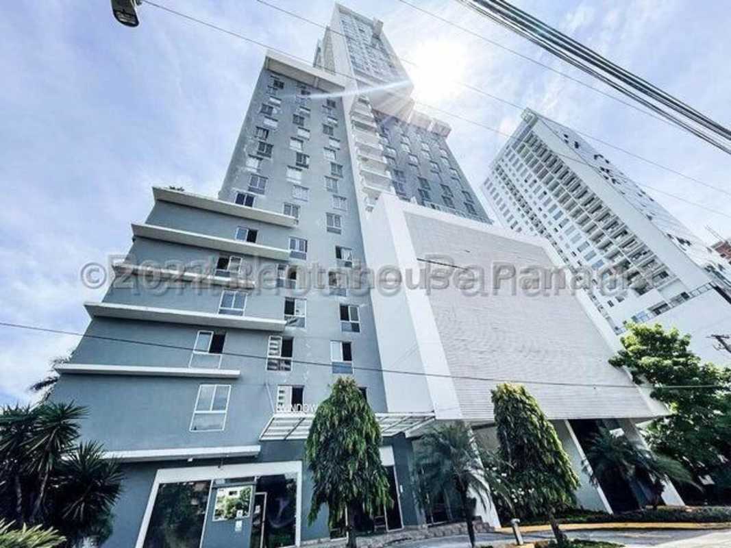 Glass dining table with wood floors, built-in shelves, natural light in apartment PH Serrano Panama City