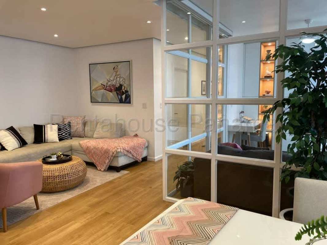 Bright living room with glass partition, sofa and wood flooring in PH Serrano Panama