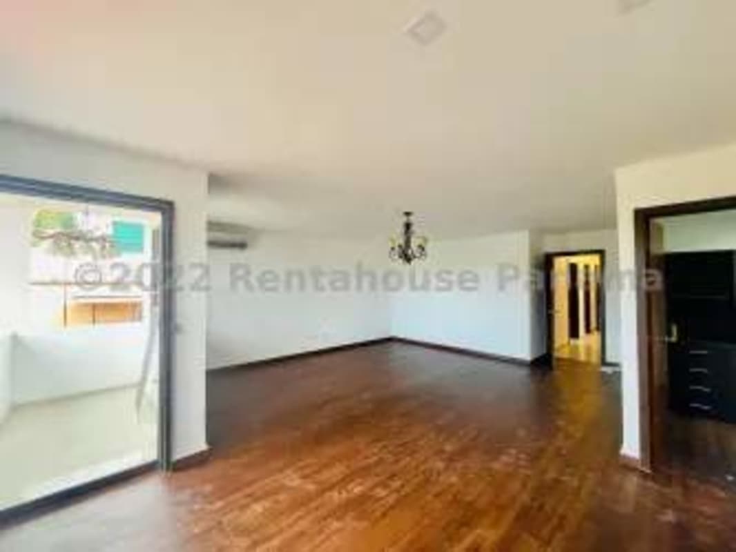 Spacious living room with wooden floors and chandelier in El Doral House Panama City