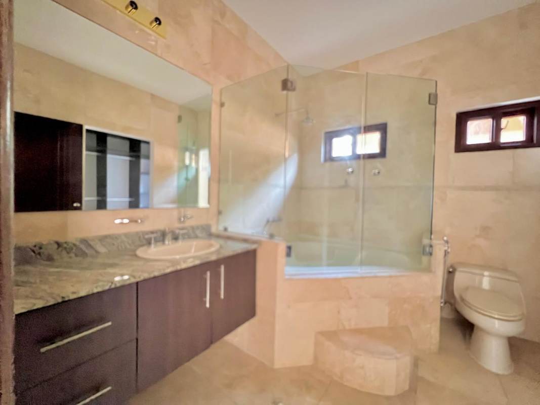 Modern bathroom with glass shower enclosure and marble countertop Costa Sur Panama