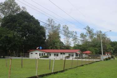 Spacious living room with stone fireplace and pink accent wall, Natá Coclé home sale