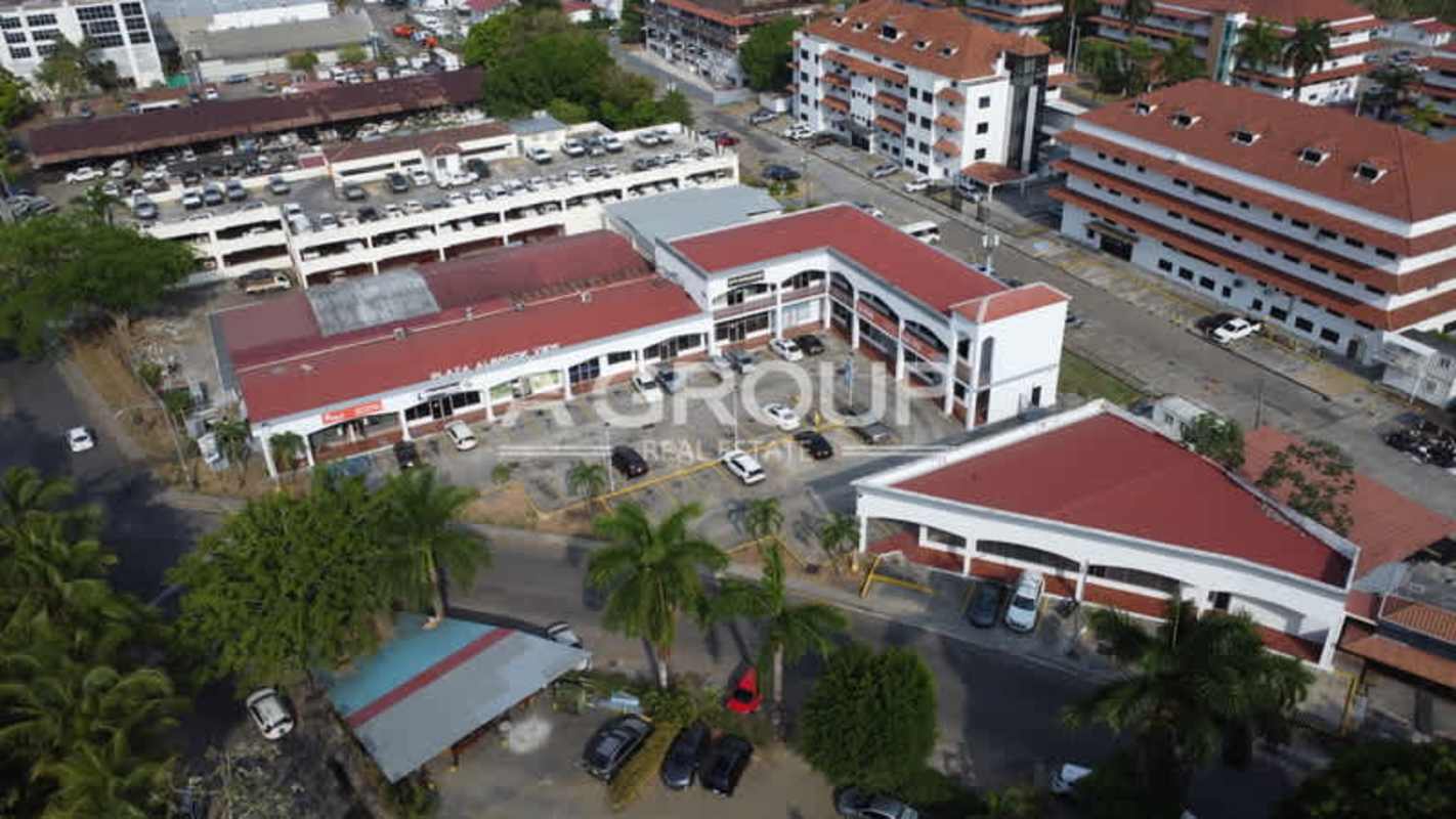 Front aerial view of Albrook View Plaza showing red tiled roof buildings, parking and access roads