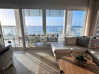 Bright living room with floor-to-ceiling glass doors, balcony and ocean view at Playa Escondida Maria Chiquita