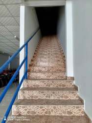 Staircase in commercial double-story property with patterned tiled stairs and blue railings