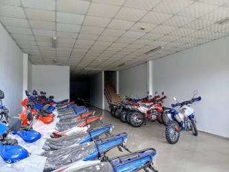 Storefront showroom with multiple motorcycles and staircase, open commercial property rental in David Panama