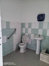 Functional bathroom with toilet, pedestal sink, tiled walls inside commercial rental Doleguita David Panama