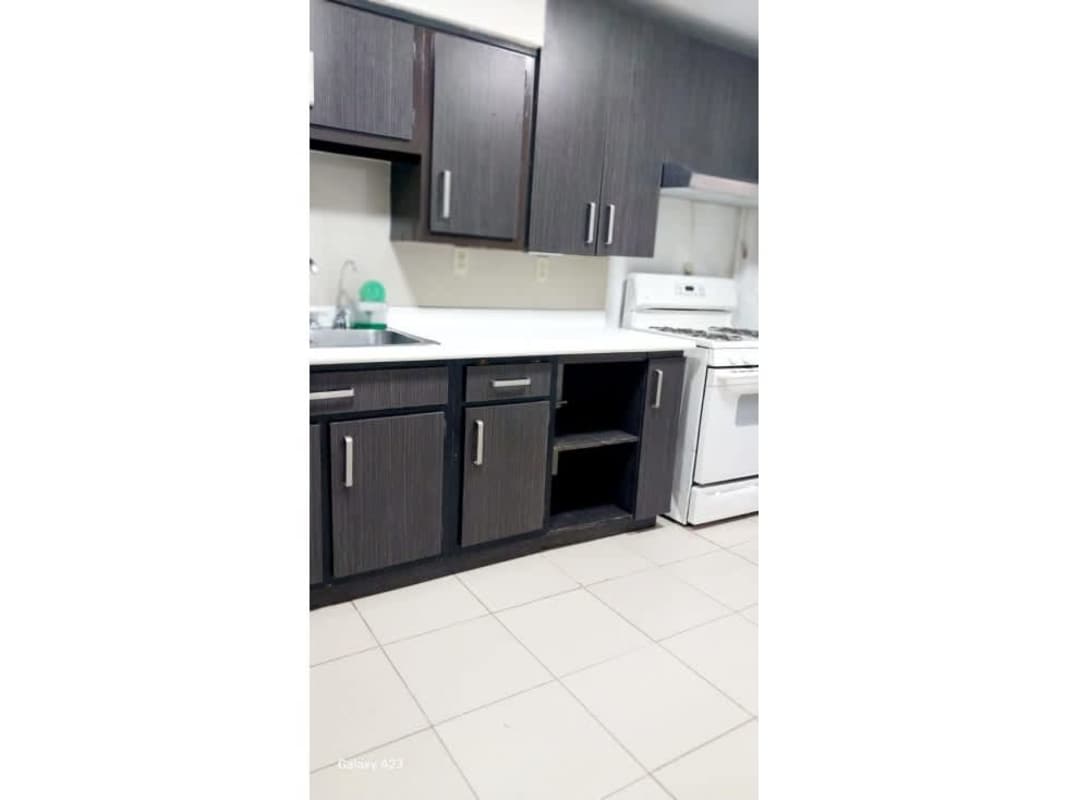 Kitchen with dark cabinets and appliances in furnished Clayton apartment rental