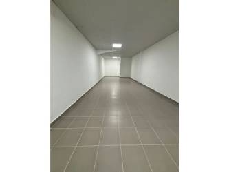Long interior hallway with ceramic tiles and recessed lights in commercial space Las Mañanitas Panama