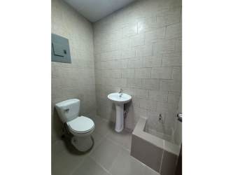 Minimalist restroom with pedestal sink toilet beige tile at Las Mañanitas Panama City