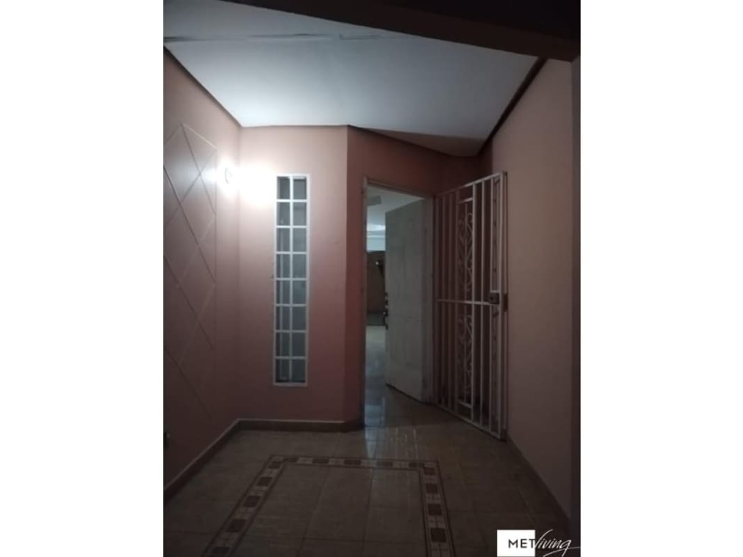 Entrance hall with glass block window, decorative tiles, and security door Villa Lucre Panama