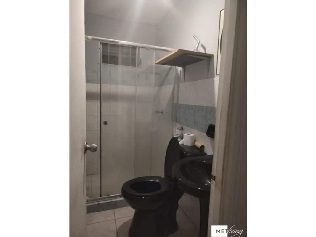 Traditional kitchen with dark wood cabinets, double sink and black countertops in Altos de la Castellana Panama