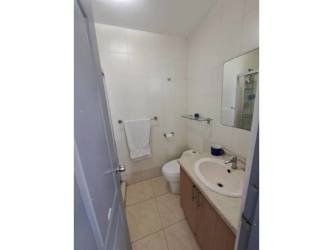 Modern compact bathroom with tiled walls, vanity sink, and mirror at PH Albrook Point Panama