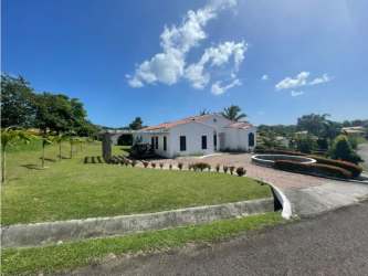 Large bedroom with window overlooking garden, AC unit, and ceiling fan in Hacienda Pacifica house Panama