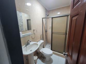 Modern bathroom with glass shower, pedestal sink, tile walls beach rental Las Lajas Gardens Coronado Panama