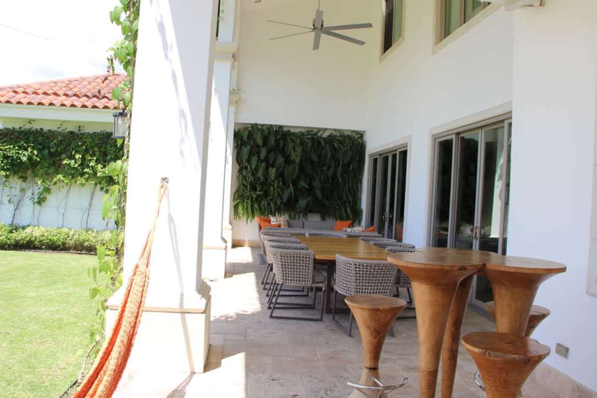 Covered outdoor dining and lounge with vertical garden wall in luxury home Santa María Panama
