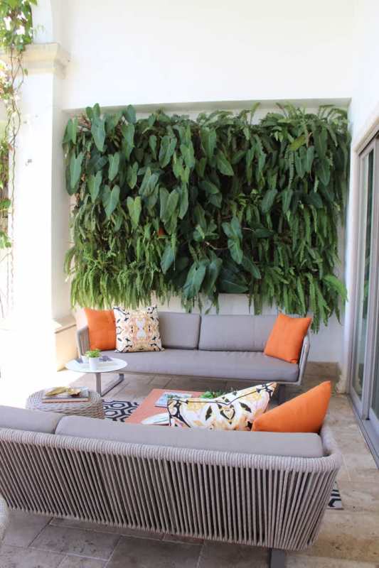 Modern covered patio with green wall vertical garden, dining area and outdoor lounge Santa María