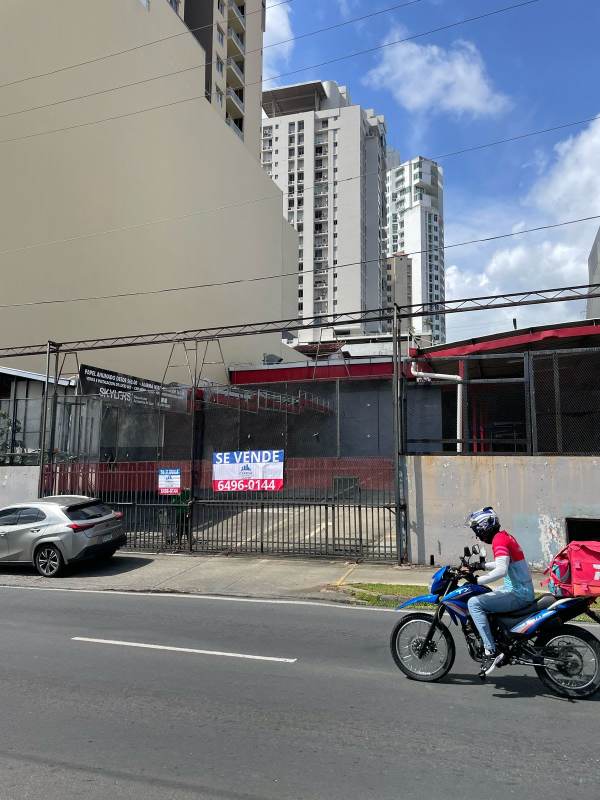 Fenced commercial lot with advertising signage on busy 12 de Octubre avenue, Panama City
