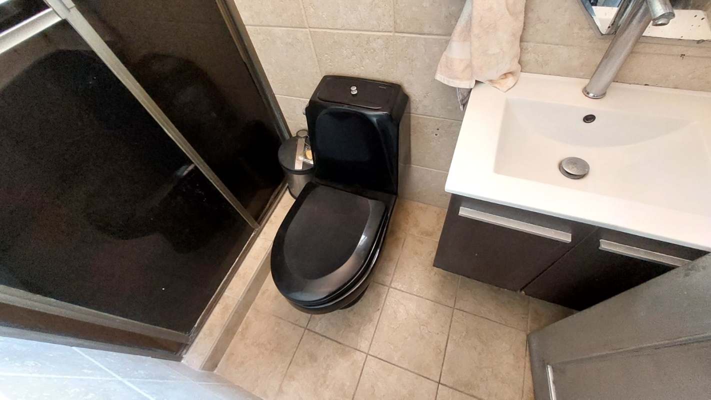 Contemporary furnished master bedroom with tufted headboard, vanity, and wardrobe in Condado del Rey Panama