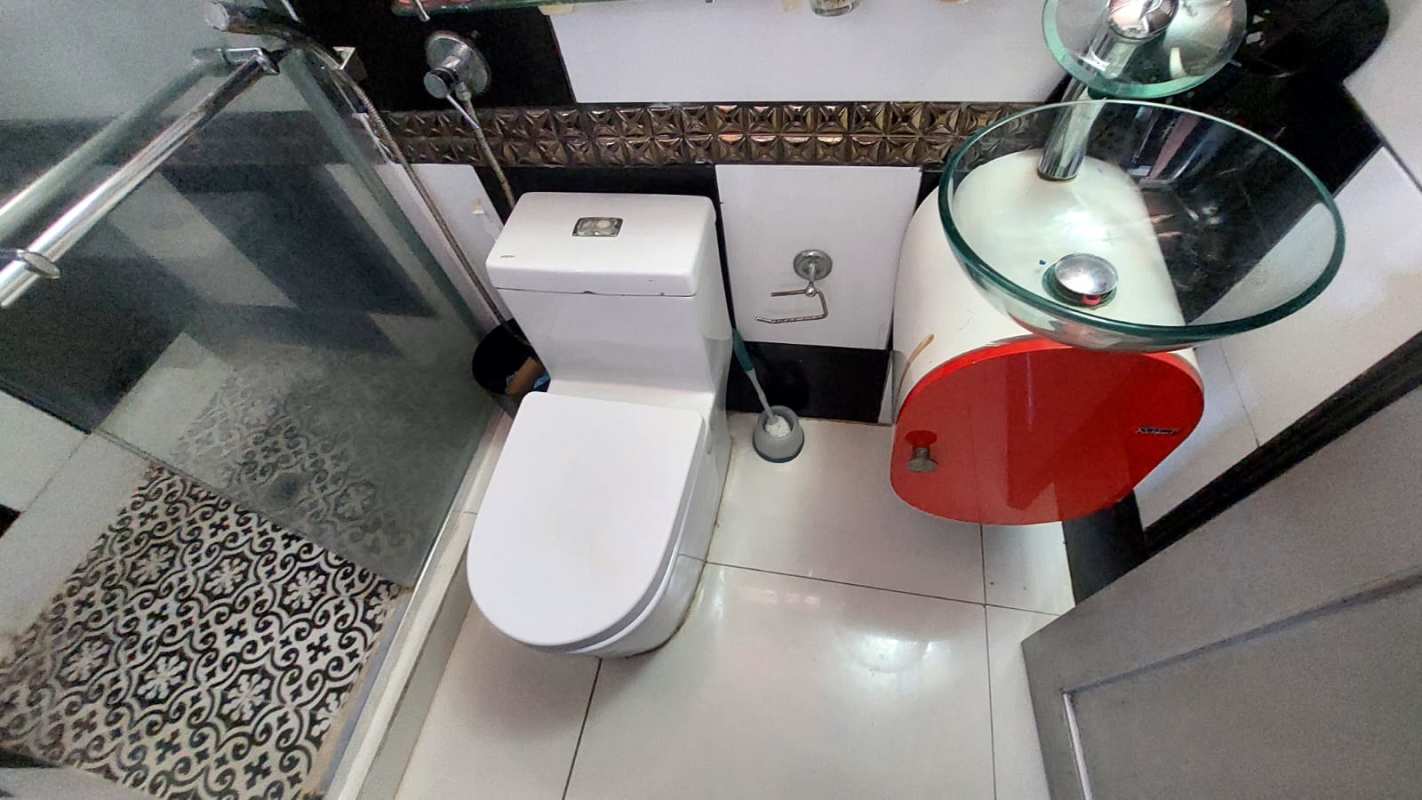 Contemporary bathroom with black toilet, glass shower door, wall tiles in Condado del Rey Panama