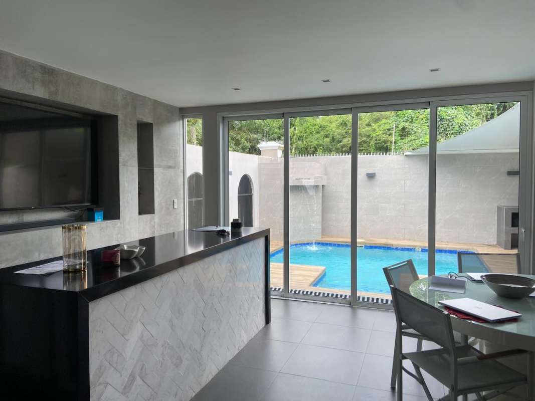 Traditional kitchen with granite countertops, wood cabinetry and stainless steel appliances in Costa Bay house Costa del Este Panama