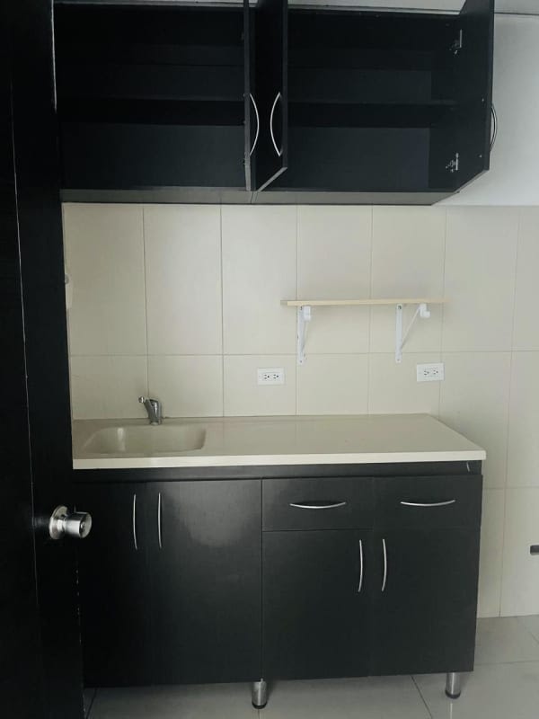 Compact kitchenette area with dark cabinetry and granite countertop inside PH BICSA Tower office space