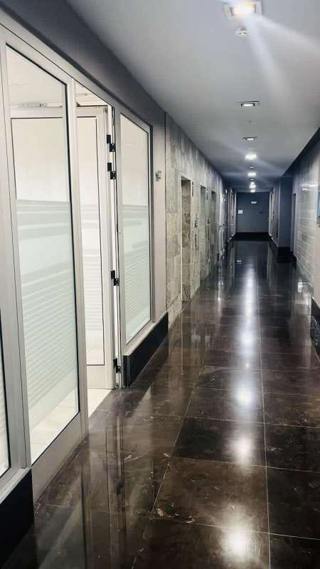 Interior hallway with glass entrance to offices, marble flooring in PH BICSA Tower