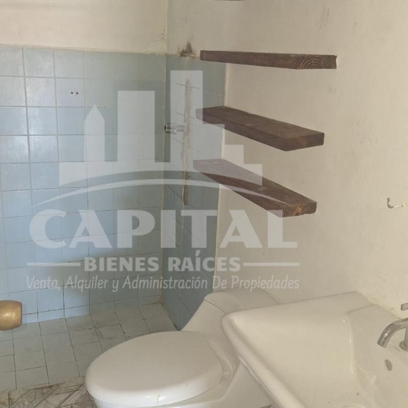 Simple bathroom with blue wall tiles, shelves, sink and toilet in Don Bosco house Panama