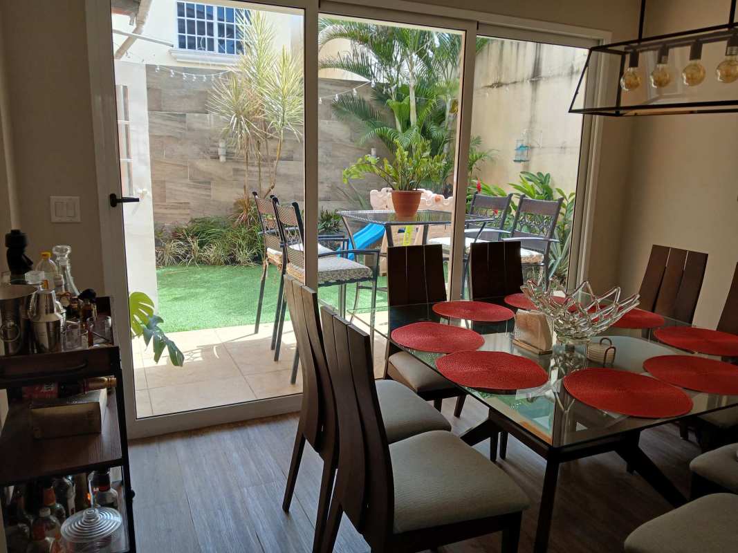 Dining space with sliding door leading to backyard terrace at Villa Lucre house Panama