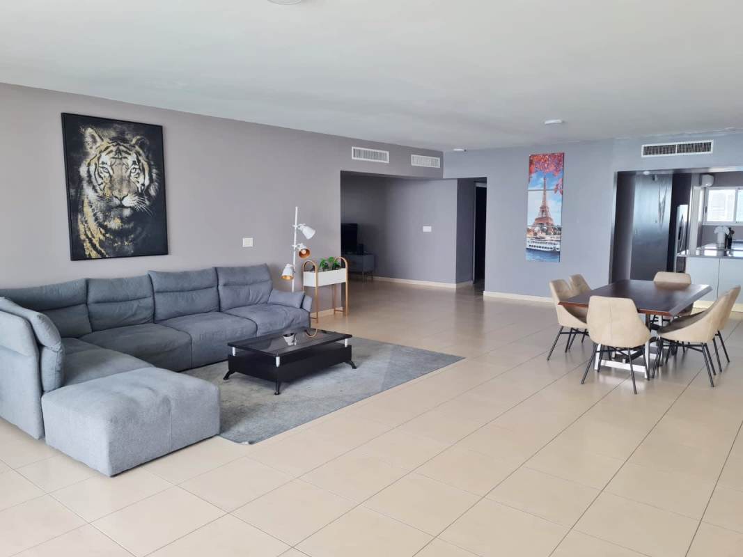 Spacious living dining area with large windows and furnished oceanfront balcony in PH Waters Panama