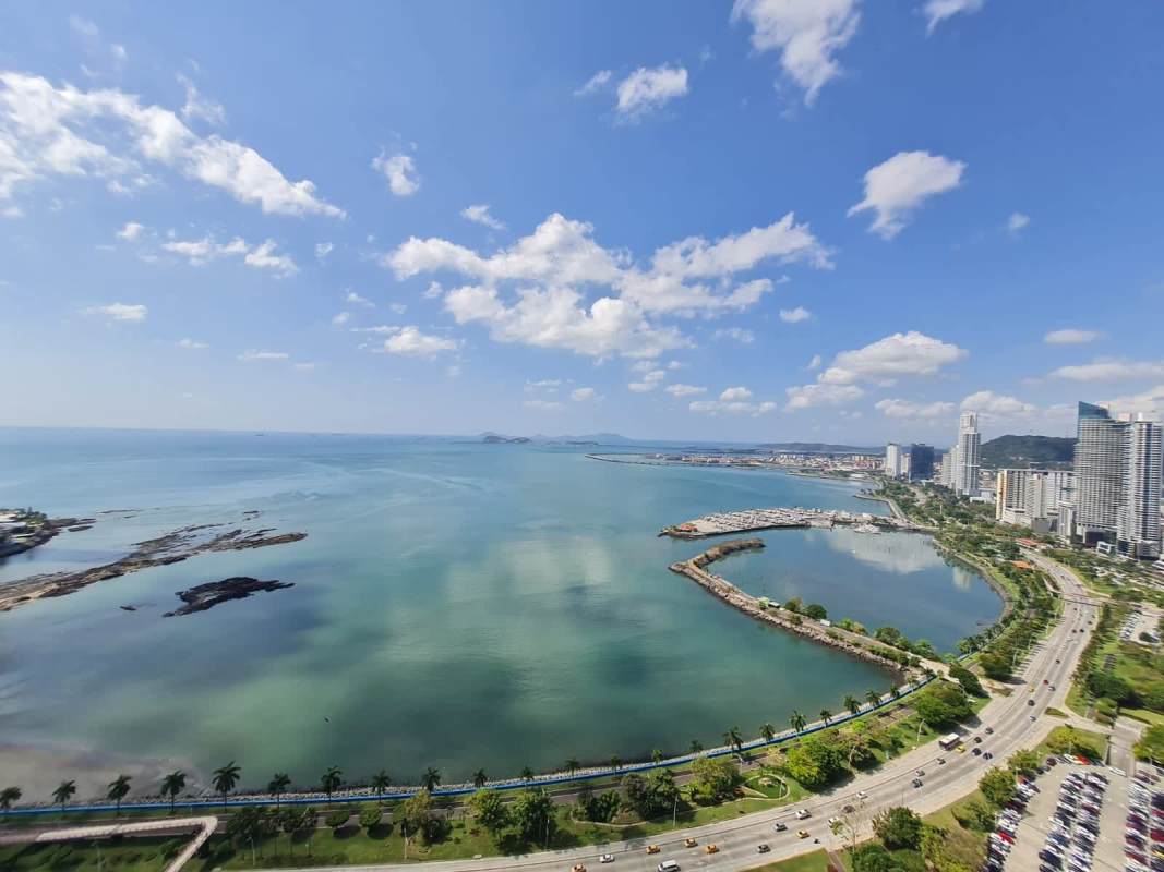 Infinity pool with sun loungers and oceanfront view at Avenida Balboa Panama