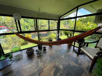 Dining room with glass table, modern decor, air conditioning, and bright windows in Clayton Panama