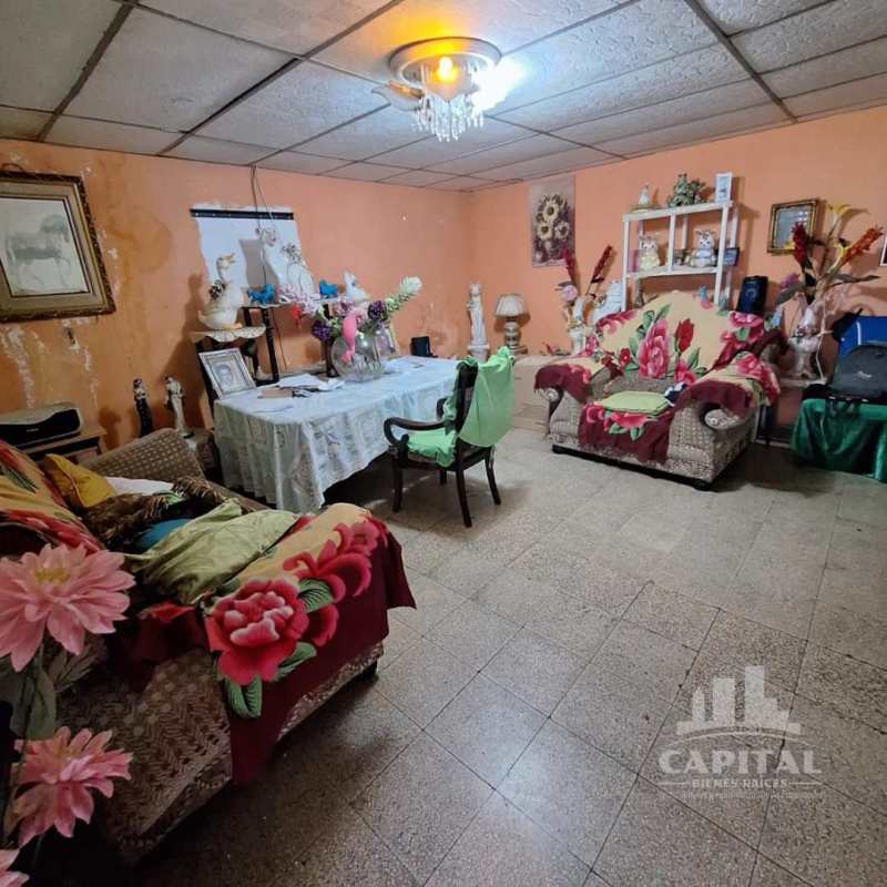 Spacious living room with traditional decor and orange walls in Don Bosco Panama home