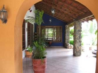 Cozy living room with wicker armchairs, exposed wood beams and built-in shelves