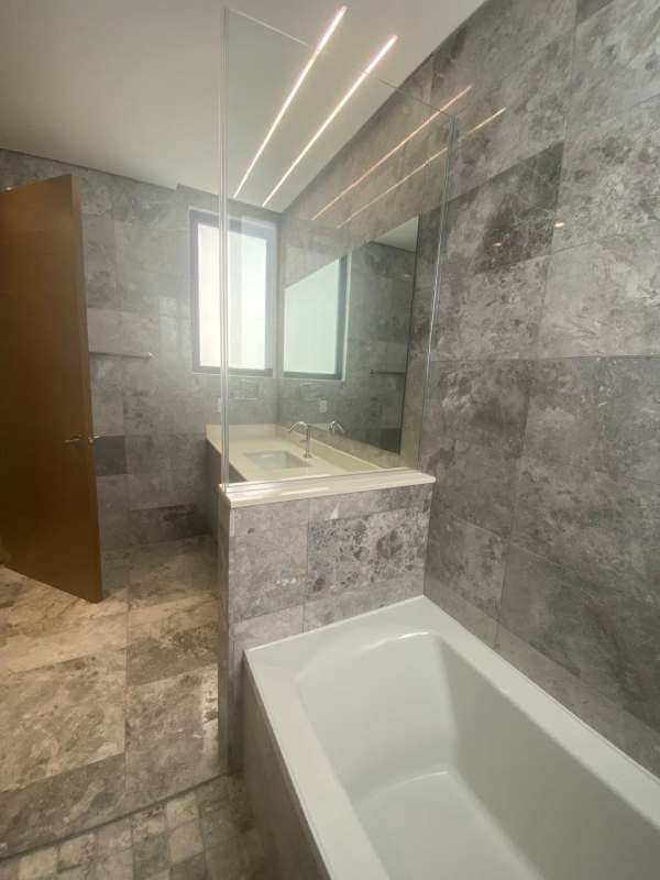 Modern open-plan living dining area with marble floors and balcony in Empire Residences Santa María